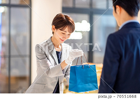 紙袋を渡す女性店員 撮影協力:g GIFT AND LIFESTYLE 紙袋を渡す女性店員 撮影協力:g GIFT AND LIFESTYLE 70551668