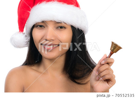 A young woman with santa claus hat holding a small bell A young woman with santa claus hat holding a small bell 70552535