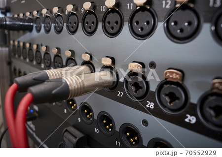 instrument audio jack connectors inserted into channels on a mixing desk in a recording studio 70552929