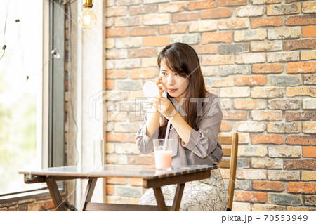 カフェで肌荒れを気にする女性 カフェで肌荒れを気にする女性 70553949