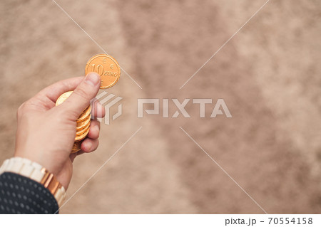 Gold coins in hand on light background 70554158