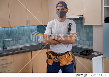 Young caucasian repairman in face mask working with furniture 70554195