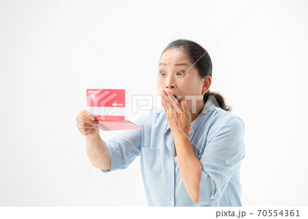 通帳を見て驚くシニア女性 通帳を見て驚くシニア女性 70554361