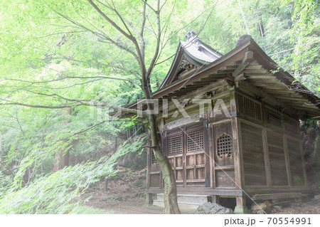 霧でかすむ山の中の古いお堂 70554991