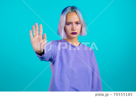 Pretty woman with violet hair disapproving with NO hand sign gesture. Denying, rejecting, disagree Pretty woman with violet hair disapproving with NO hand sign gesture. Denying, rejecting, disagree 70555185