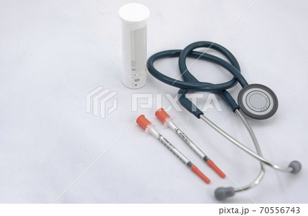 Two syringes with cap, stethoscope and medicine canister on white background 70556743