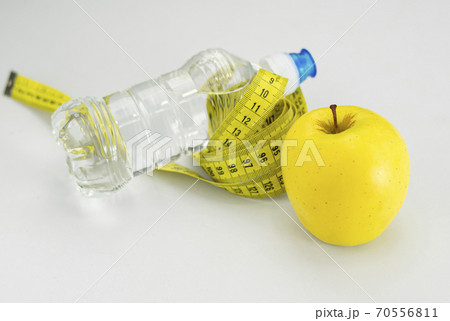 Apple, water and a measuring tape for an intense diet 70556811