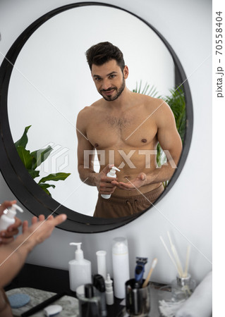 Waist up shot of man looking to himself through the mirror 70558404