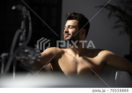 Close up shot of handsome man with beard in bathtub Close up shot of handsome man with beard in bathtub 70558866