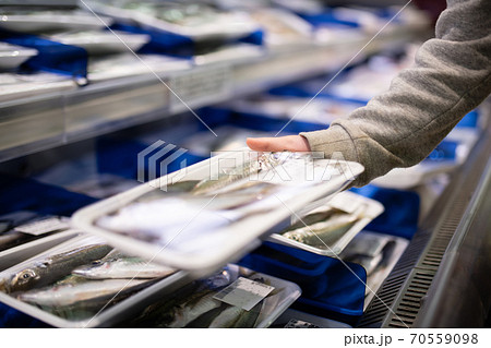 スーパーマーケットで魚を手に取る子供の手 スーパーマーケットで魚を手に取る子供の手 70559098