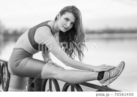 Sports and healthy lifestyle : Brunette girl doing sports exercises. Black and white photo. BW 70561450