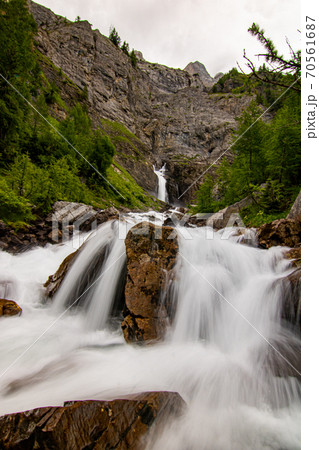 Small waterfalls streaming in green forest in long exposure. water in motion - swiss Alps 70561687
