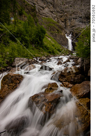 Small waterfalls streaming in green forest in long exposure. water in motion - swiss Alps Small waterfalls streaming in green forest in long exposure. water in motion - swiss Alps 70561692