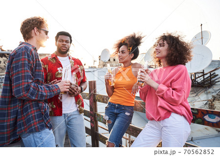 Happy young people spending summer evening together Happy young people spending summer evening together 70562852