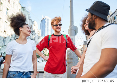 Jolly young friends standing in urban street Jolly young friends standing in urban street 70563185