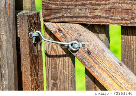Wooden door locked on a metal hook 70563246