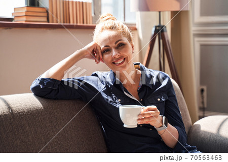Positive young lady relaxing at home on sunny day 70563463