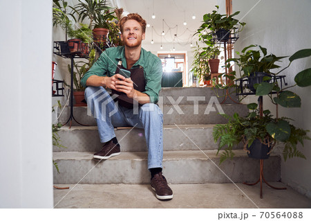 Handsome worker sitting on stairs 70564088