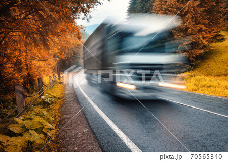 Blurred truck on the road in autumn foggy forest in rainy day 70565340