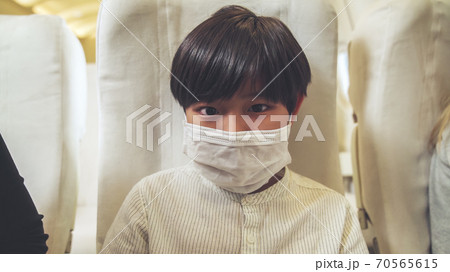 Traveler wearing face mask while traveling on commercial airplane . 70565615