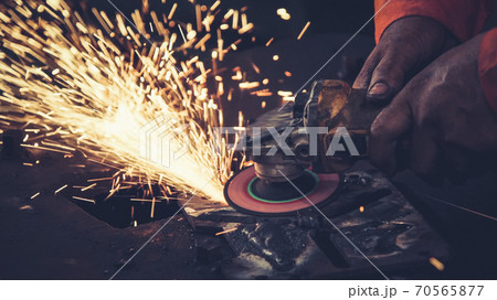 Professional mechanic is cutting steel metal. Professional mechanic is cutting steel metal. 70565877