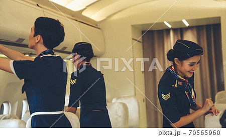 Cabin crew lift luggage bag in airplane Cabin crew lift luggage bag in airplane 70565960