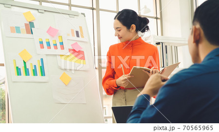 Young woman explains business data on white board 70565965