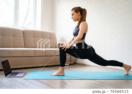 girl is engaged in sports at home, stretching. 70566515