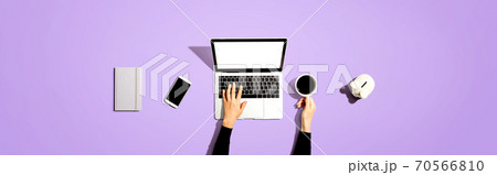 Person using a laptop computer with a piggy bank Person using a laptop computer with a piggy bank 70566810