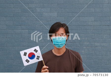 Masked man in brown shirt and South Korea flag in hand. Masked man in brown shirt and South Korea flag in hand. 70573130