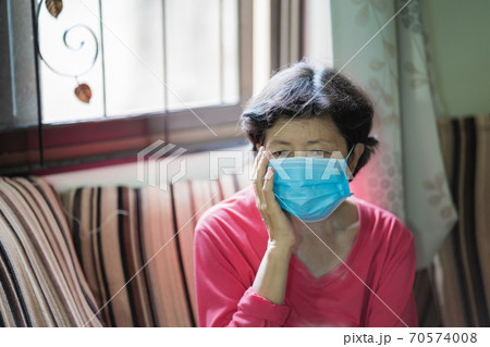 old women have a headache sitting on sofa old women have a headache sitting on sofa 70574008