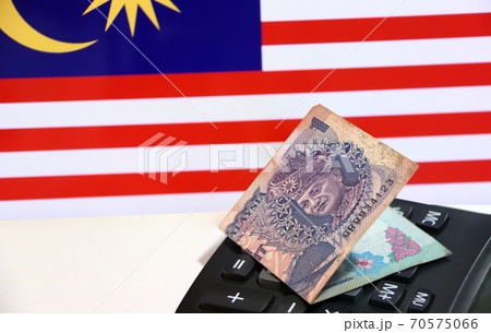 One ringgit banknote of Malaysia on calculator on the white floor with Malaysian nation flag One ringgit banknote of Malaysia on calculator on the white floor with Malaysian nation flag 70575066