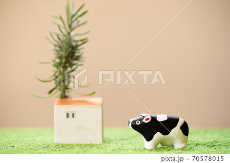 （2021年・丑年）年賀状で使える、草原の中に佇む置物の牛 70578015