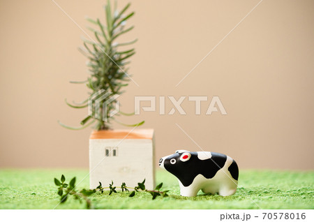 （2021年・丑年）年賀状で使える、草原の中に佇む置物の牛 70578016