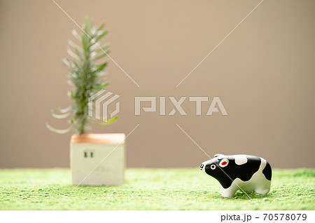 （2021年・丑年）年賀状で使える、草原の中に佇む置物の牛 70578079