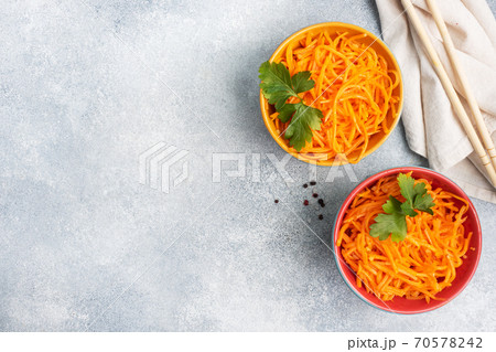 Raw grated spicy carrot salad in bowl. Korean carrot with spices and sauce. Copy space 70578242