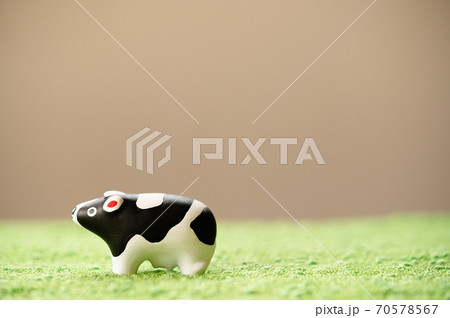 （2021年・丑年）年賀状で使える、草原の中に佇む置物の牛 70578567