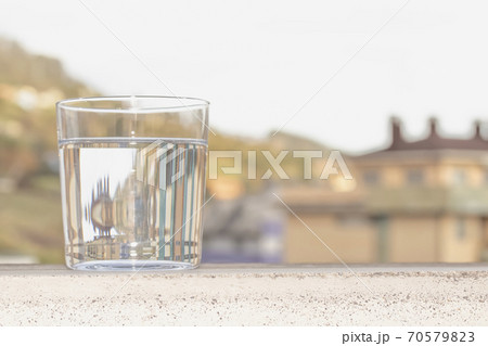 A glass of clear water on the background of a city street A glass of clear water on the background of a city street 70579823