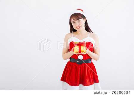 プレゼントを渡すサンタコスの女の子の写真素材