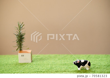 (2021年・丑年)年賀状で使える、草原の中に佇む置物の牛 (2021年・丑年)年賀状で使える、草原の中に佇む置物の牛 70581323