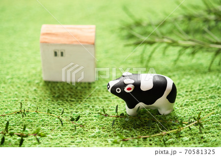 （2021年・丑年）年賀状で使える、草原の中に佇む置物の牛 70581325