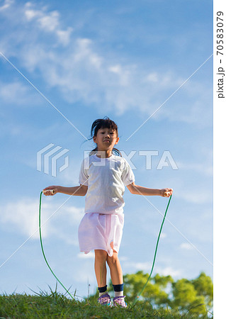 夏の公園で縄跳びを遊んでいる可愛い子供の写真素材