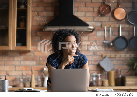 Smiling African American woman dram distracted from computer work Smiling African American woman dram distracted from computer work 70583530