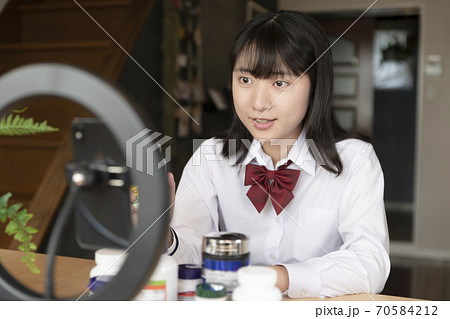 ライブ配信でサプリの紹介をする女子高生 70584212