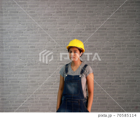 Technician woman ware yellow helmet with grey T-shirt and denim jeans apron dress Technician woman ware yellow helmet with grey T-shirt and denim jeans apron dress 70585114