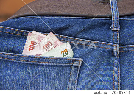 Heap banknotes of Thailand in the back of blue jeans pocket. Back blue jeans pocket and Thai money Heap banknotes of Thailand in the back of blue jeans pocket. Back blue jeans pocket and Thai money 70585311