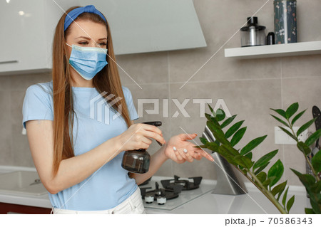 Woman splashes a flowerpots at home 70586343