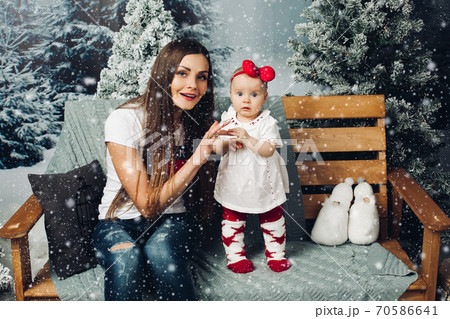 Loving mother decorating Christmas tree with baby. Loving mother decorating Christmas tree with baby. 70586641