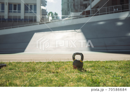 heavy iron kettlebell in green grass - outdoor fitness concept 70586684