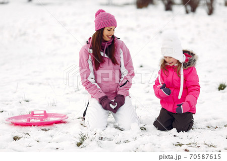 Mother and child in winter clothes play in winter park 70587615
